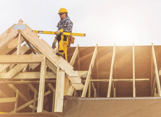 Construction worker in a hard hat and safety vest uses a spirit level to ensure precise alignment on a wooden roof frame at a job site, sunlight streaming behind—demonstrating the same attention to detail and quality service provided by Pipeworks Plumbing and Construction. Construction worker in a hard hat and safety vest uses a spirit level to ensure precise alignment on a wooden roof frame at a job site, sunlight streaming behind—demonstrating the same attention to detail and quality service provided by Pipeworks Plumbing and Construction.